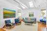 Living room with lofted ceiling with skylight, hardwood / wood-style floors, and a wealth of natural light