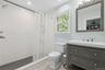 Bathroom featuring a shower stall, vanity, and light tile patterned floors