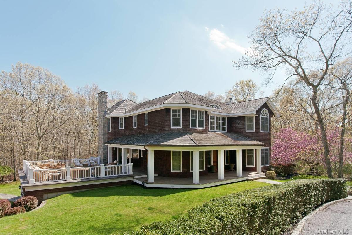 Rear view of property with a chimney, a lawn, and a shingled roof