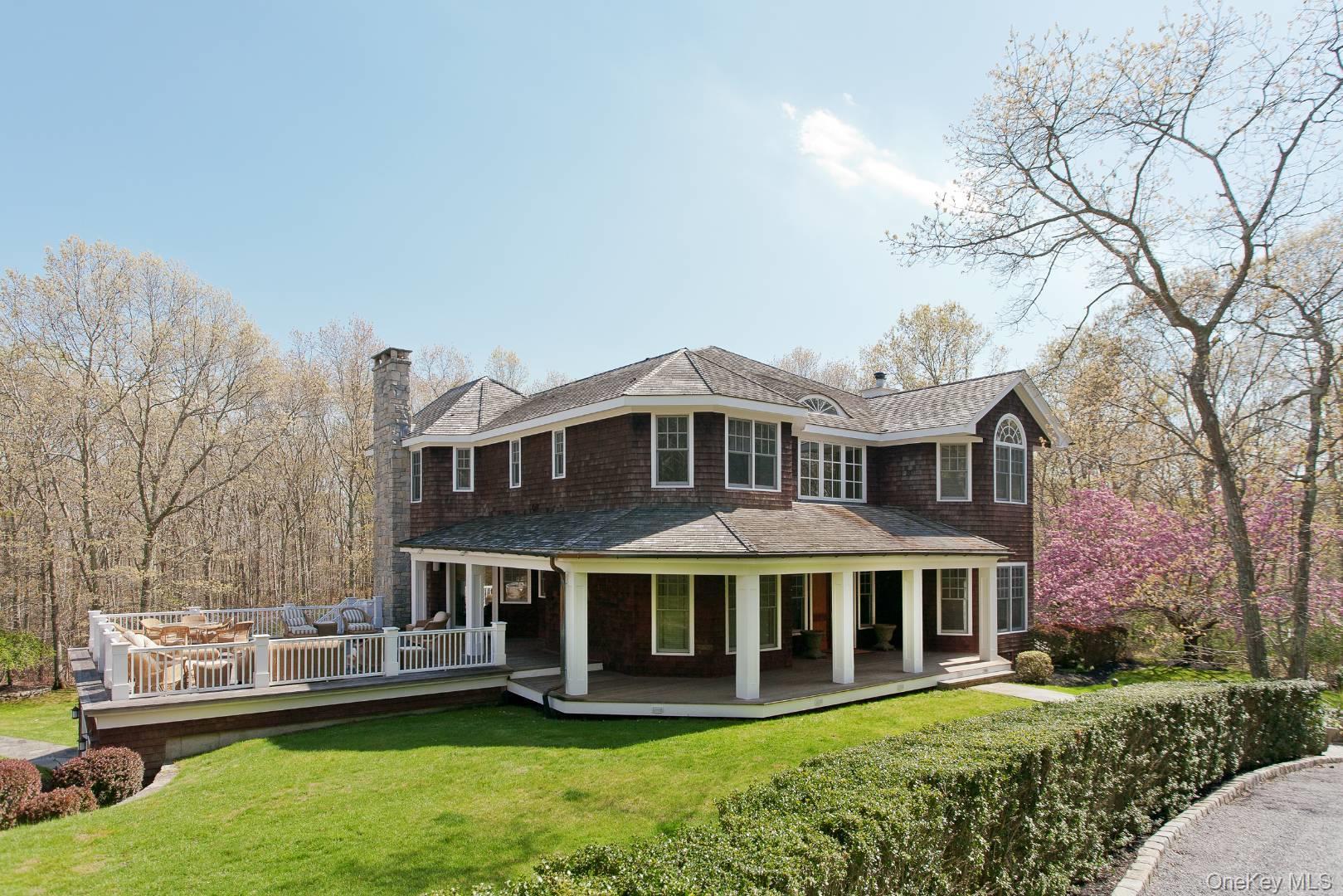 Rear view of property with a chimney, a lawn, and a shingled roof