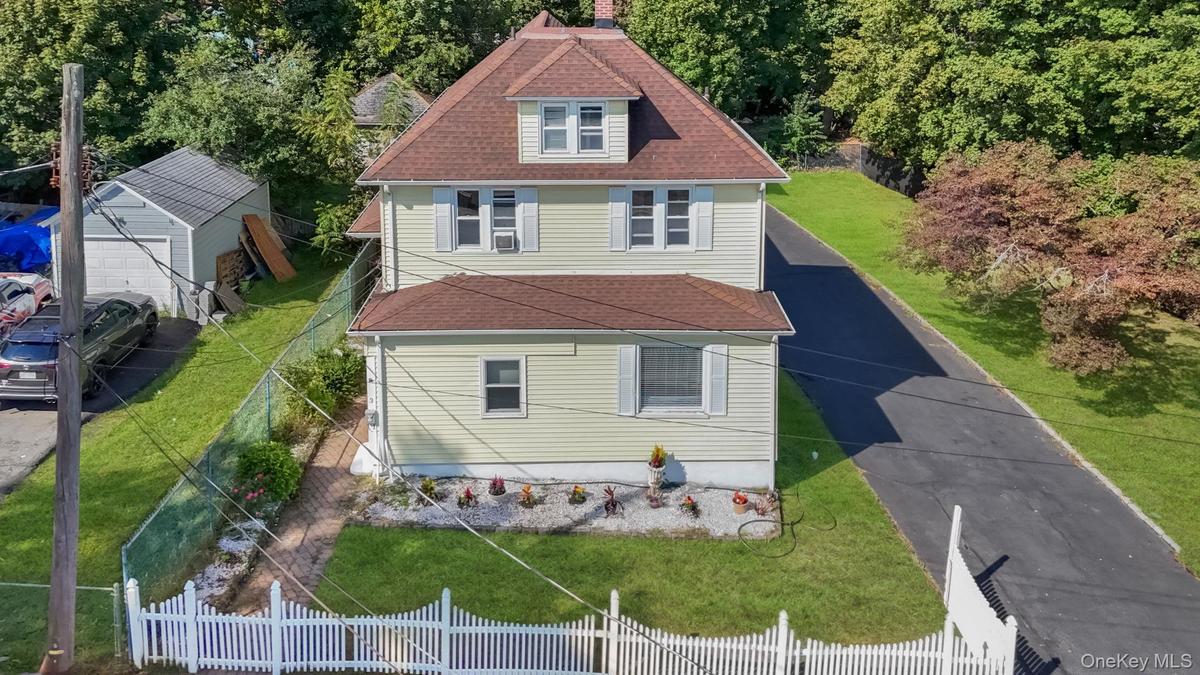 View of front of home featuring a shingled roof and a chimney