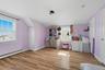 Bedroom featuring radiator, wood finished floors, vaulted ceiling