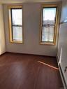 Empty room with a baseboard radiator and dark wood finished floors