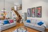 Living room with hardwood / wood-style flooring, stairs, a towering ceiling, plenty of natural light, and a chandelier