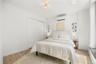 Bedroom featuring baseboards, a wall mounted air conditioner, a closet, and light wood finished floors