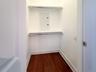 Walk in closet featuring electric panel and dark wood-style flooring