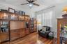 Private front office with wood flooring and ceiling fan.