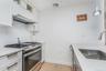 Kitchen with stainless steel appliances, light wood-type flooring, tasteful backsplash, and white cabinets