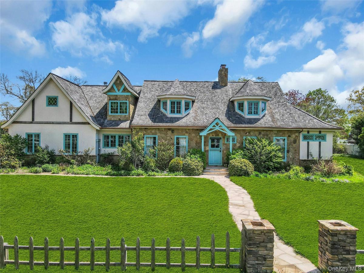 Stone and stucco exterior featuring a prominent teal front dutch door and complementary trim