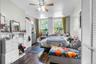 Bright interior space featuring wood-finish flooring, a ceiling fan with light fixture, and two large windows