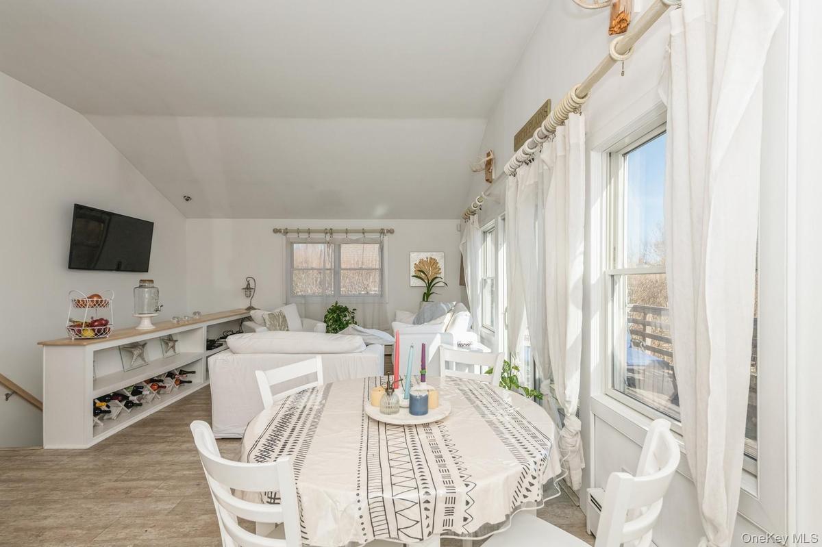 Dining room with plenty of natural light, vaulted ceiling, and light wood-style flooring