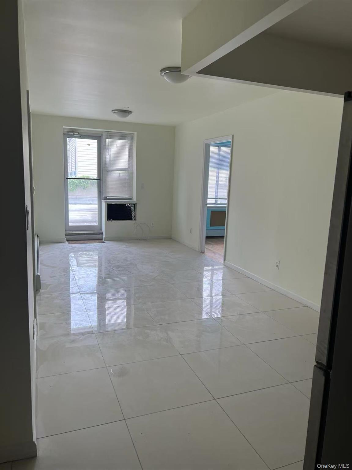 Empty room with plenty of natural light, light tile patterned flooring, and baseboards