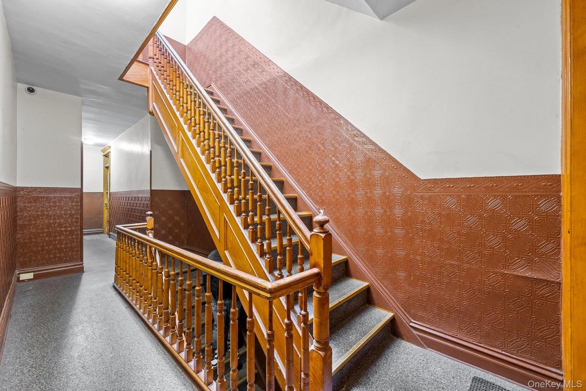 Stairway featuring a wainscoted wall