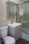Full bath with vanity, enclosed tub / shower combo, and tile walls
