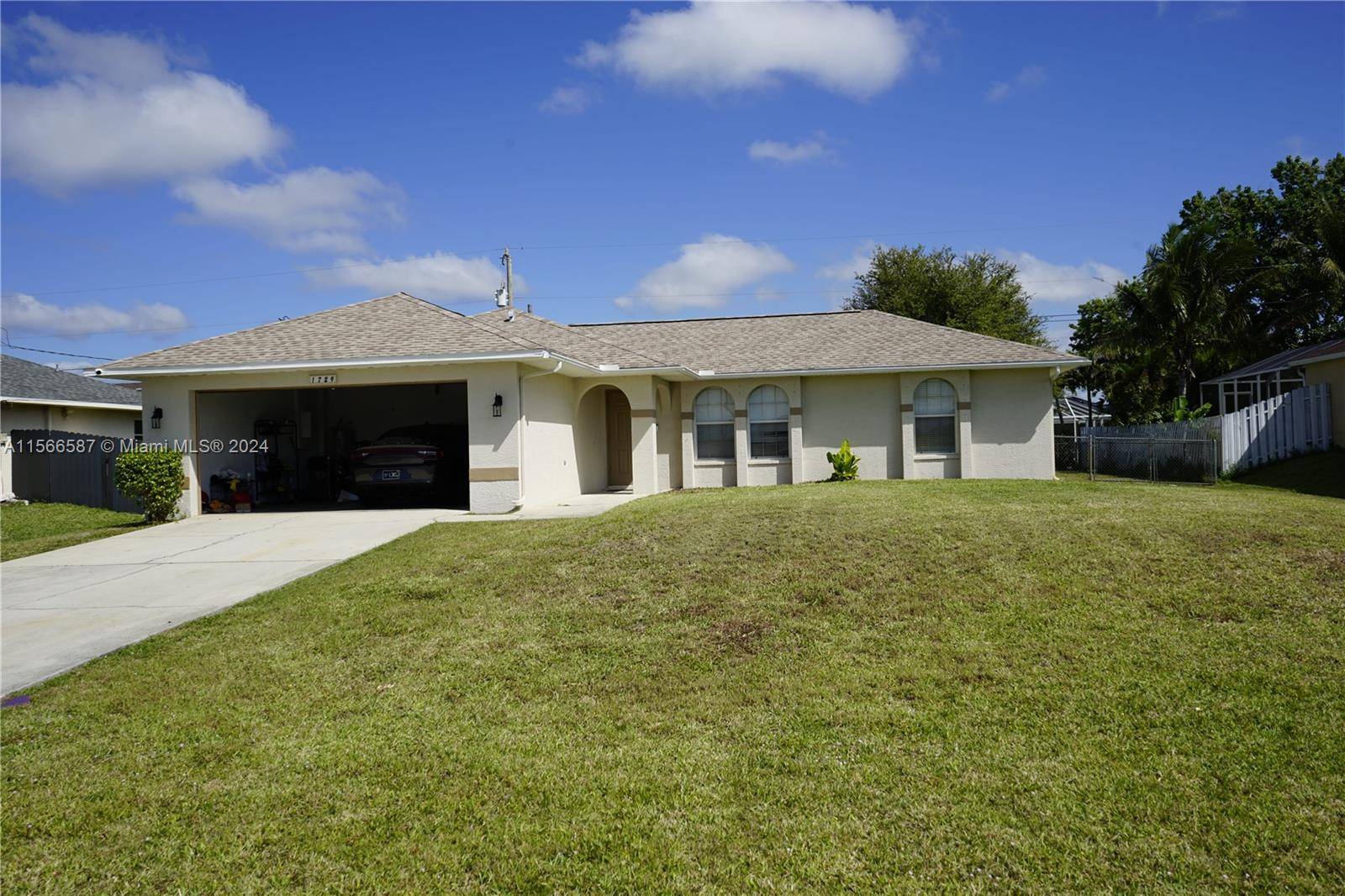 This lovely home includes 3 bedrooms, 2 bathrooms, a screened lanai, a 2 car garage with an electric gate, an open kitchen, dining, and living area.