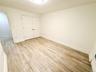Master bedroom with light wood-style floors and a closet
