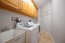 Laundry room with lots of cabinet storage and clothes hanging space plus floor space for 3 laundry baskets back in the corner. And a storage room off