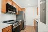 Alternative view of kitchen with all new stainless steel LG appliances, white quartz countertops, and brushed metal hardware