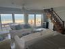 Living area featuring a water view, stairs, ceiling fan, and light tile patterned flooring