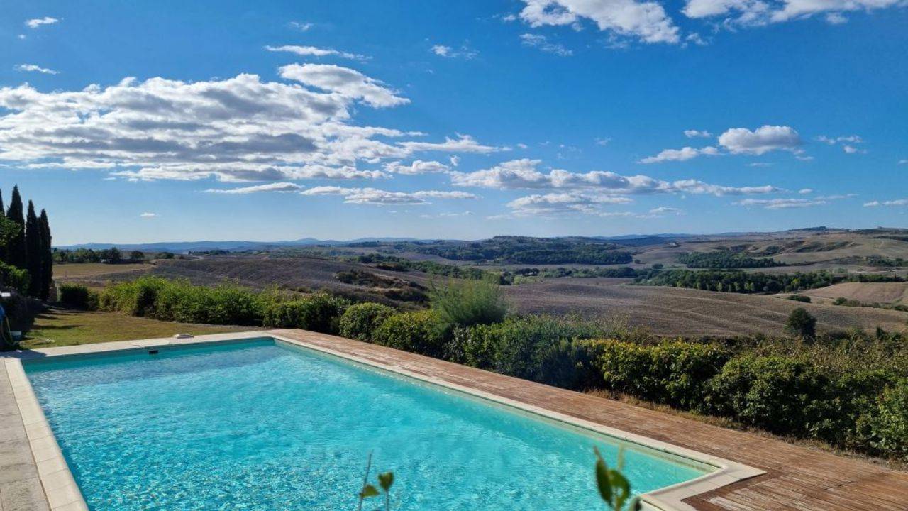 Holiday house in Tuscany. The ancient real estate built on the very top of the hill with lush garden, swimming pool, olive trees is on sale.