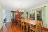 Dining room with dark wood-type flooring, a chandelier, ornamental molding, and stairway
