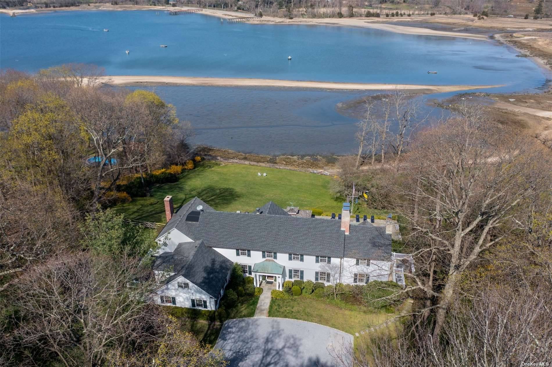 Smugglers Cove is a uniquely designed waterfront estate featuring 135 Feet of Beachfront for Sailing, Kayaking, and Fishing on two prime Oyster Bay Cove acres.