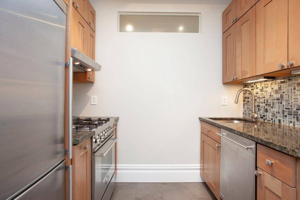 This gracious, one bedroom at 2 Beekman Place with four windows facing east offers a tranquil home overlooking trees and a view of the East River.