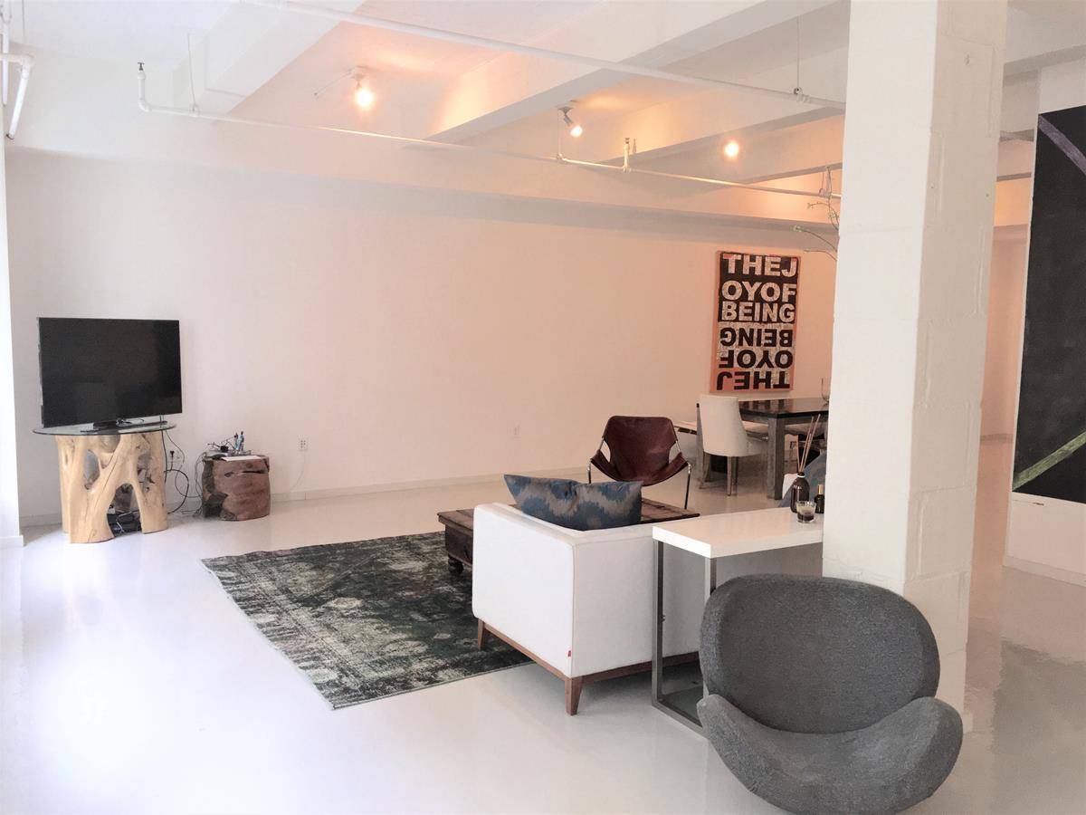 Designer 1450sf spacious live work loft that may be converted, with white epoxy resin floors, and black kitchens for a dramatic look throughout.