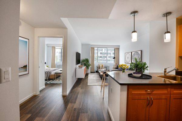 Sundrenched one bedroom with floor to ceiling windows showcasing open views across Chrystie Street.
