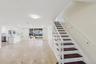 Tiled flooring with dark accent inlays, a white staircase with dark wood-finish treads, and recessed lighting