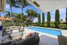 Covered patio and poolside seating in Wellington FL luxury rental home