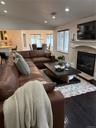 Living area featuring visible vents, wood finished floors, recessed lighting, a fireplace, and lofted ceiling