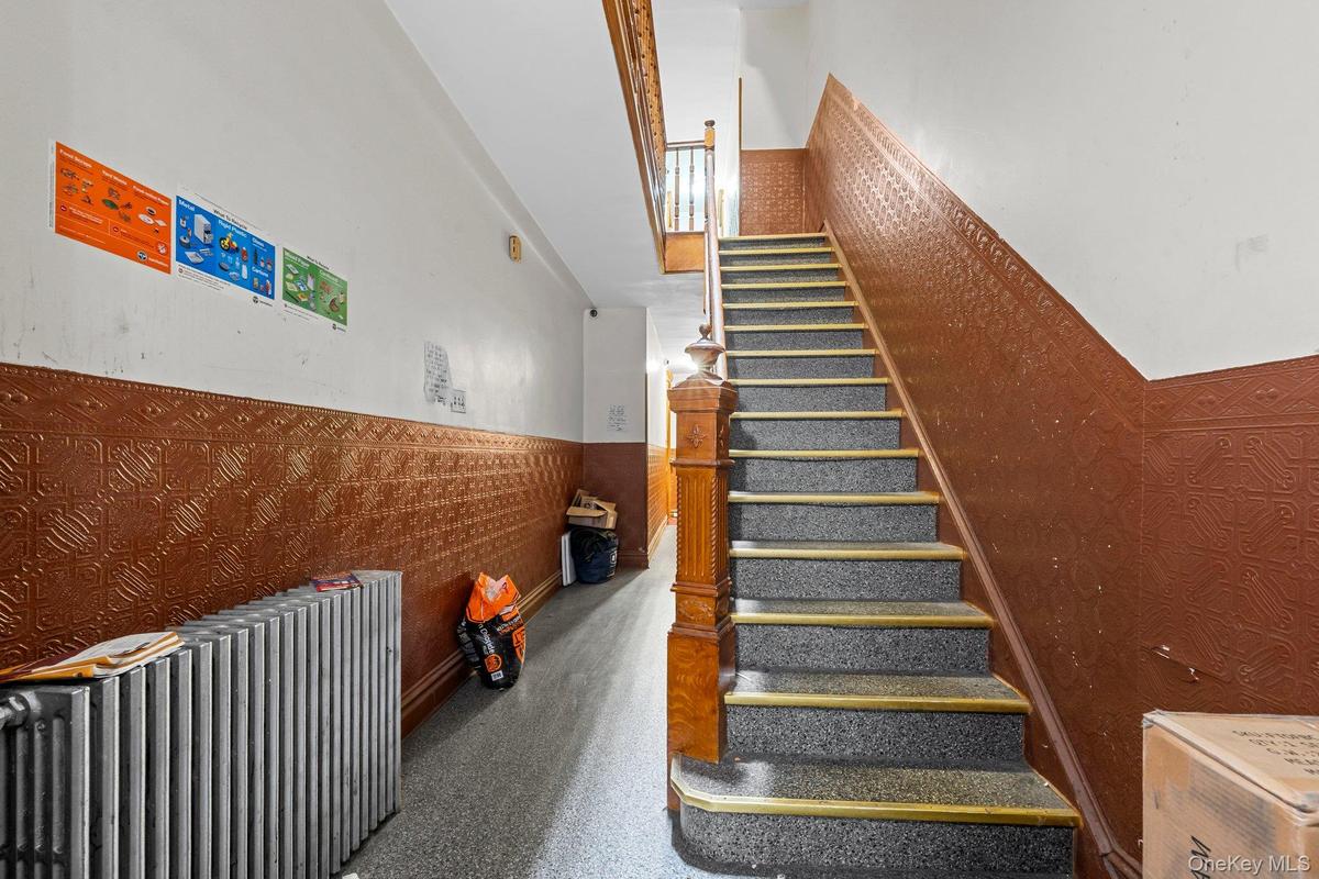 Staircase with a wainscoted wall and radiator heating unit