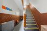 Staircase with a wainscoted wall and radiator heating unit