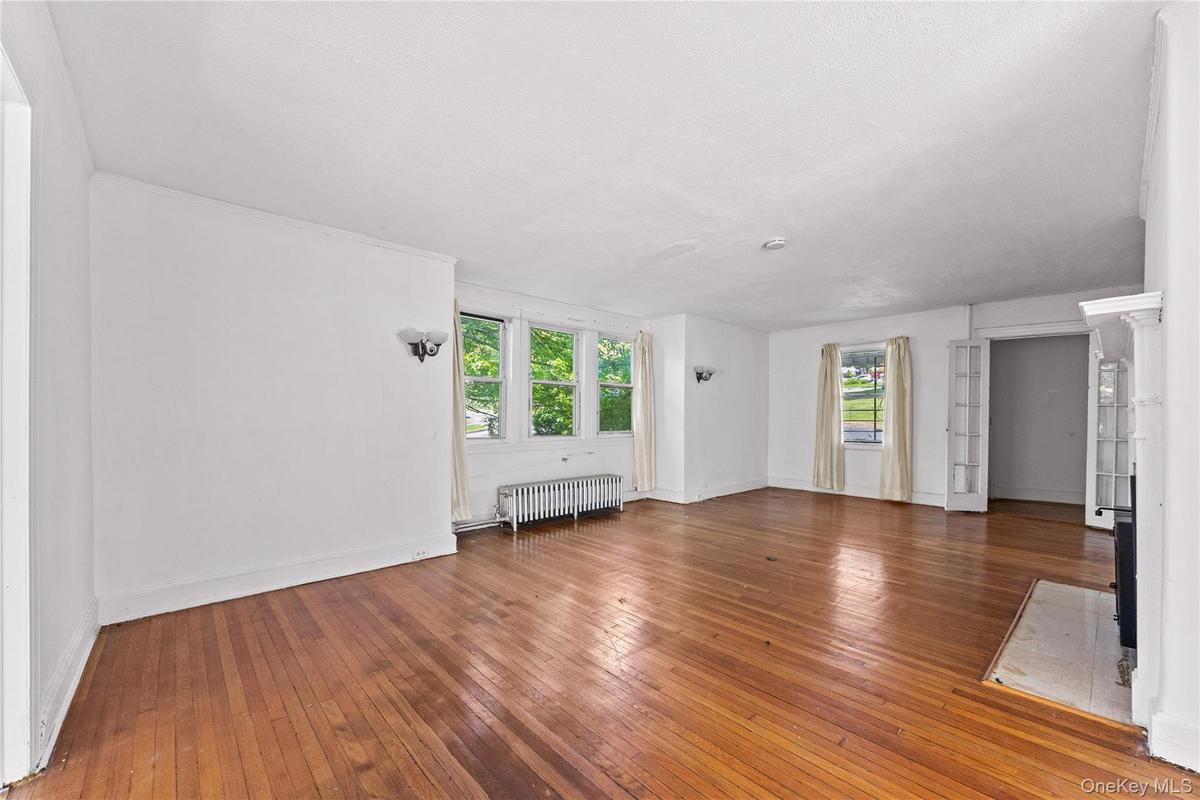 Living room with hardwood floors, great light and a fireplace.