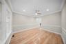 Empty room featuring a decorative wall, light wood finished floors, ornamental molding, recessed lighting, and wainscoting