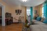 Living area with wood finished floors, ornamental molding, electric panel, and a baseboard heating unit