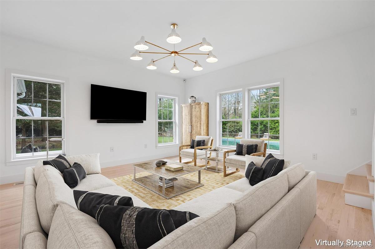 Living room featuring a chandelier, wood finished floors, and baseboards