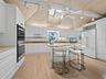 The high ceilings and light in the kitchen as well as the beautiful butcher block island welcomes family or friends to join you as you prepare meals.