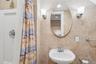 Full bath featuring a sink and a shower stall