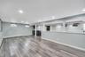 Spacious lower level featuring wood-finish flooring, recessed lighting, and a built-in wet bar with a beverage refrigerator