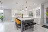 Kitchen featuring crown molding, white cabinetry, a kitchen breakfast bar, a kitchen island, and tasteful backsplash