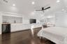 Bedroom with wine cooler, lofted ceiling, dark wood-style floors, recessed lighting, and wet bar