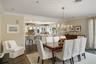 Dining space with dark wood-style flooring, ornamental molding, and a chandelier