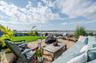 View of patio featuring a water view, a grill, and an outdoor living space with a fire pit