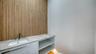 Powder room upon second floor entry features custom suspended cabinetry and large format "wood" tile