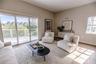 Open concept living and dining room with natural light and balcony overlooking mangroves.