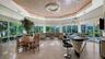 Vaulted great room for dining and entertaining with floor-to-ceiling windows, travertine floors, and a wood-paneled ceiling