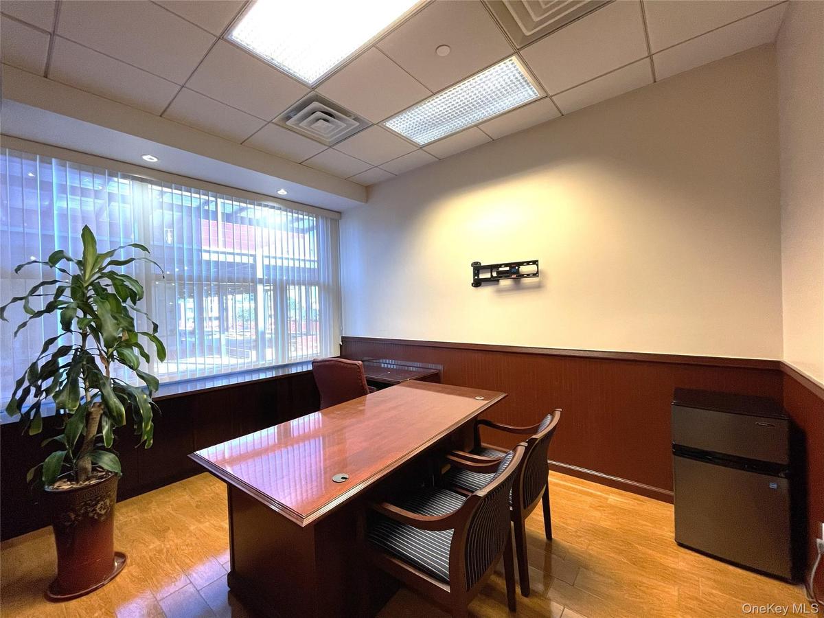 Office featuring wainscoting, a drop ceiling, and wooden walls