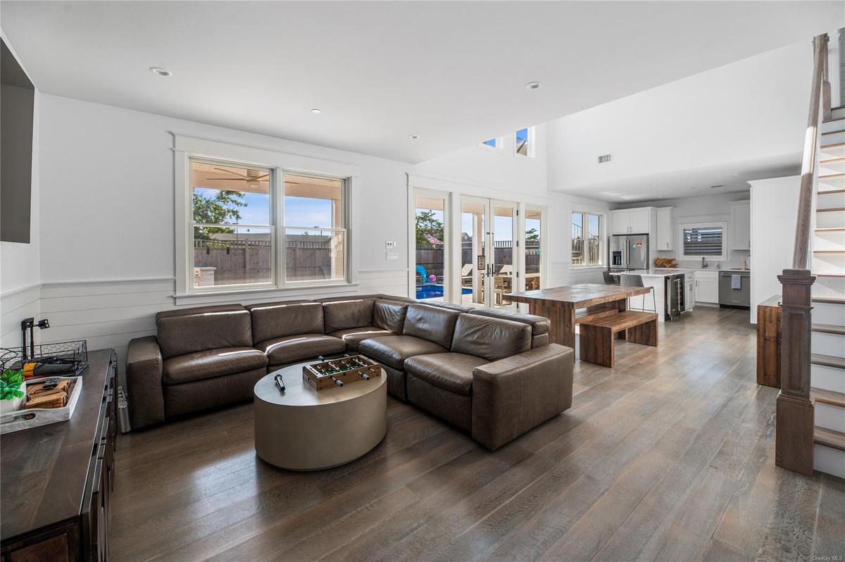 Living room with hardwood / wood-style floors, a towering ceiling, and french doors
